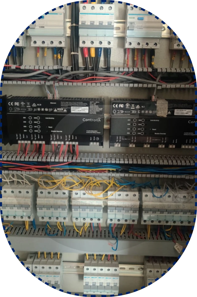 An electrical control panel with circuit breakers, labeled components, and colorful wires connecting modules.