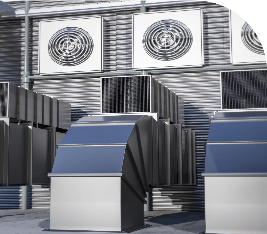 Industrial air conditioning units with large vents and ducts mounted on a building exterior.